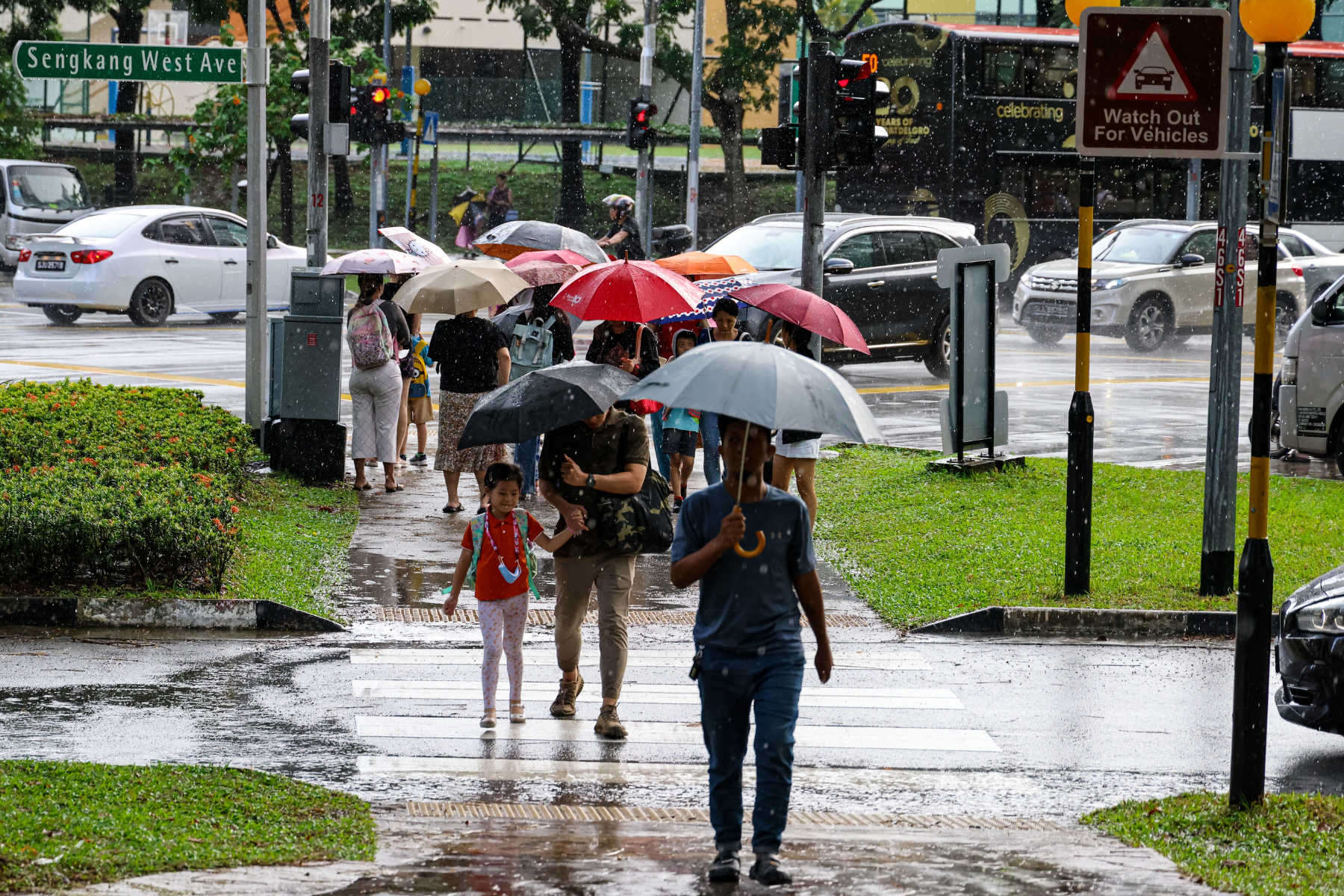 Pedestrians at a zebra crossing during a rainy day in Singapore in March