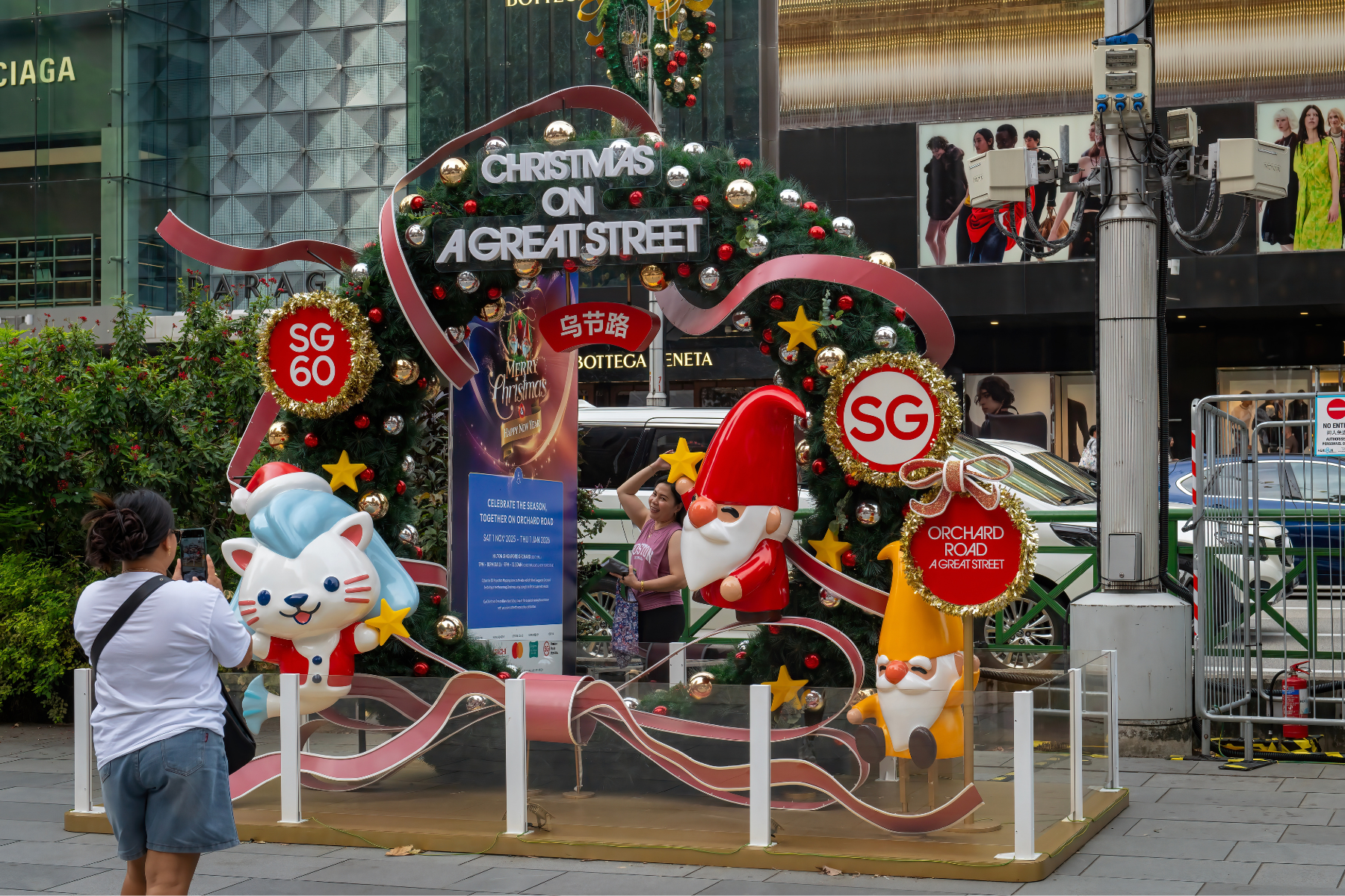 Woman taking photo with Christmas decoration on Orchard Road in Singapore